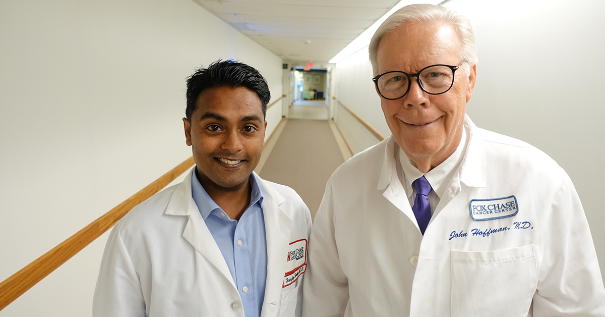 A photograph of Dr. Sanjay Reddy and Dr. John Hoffman standing together in a hallway and smiling at the camera.